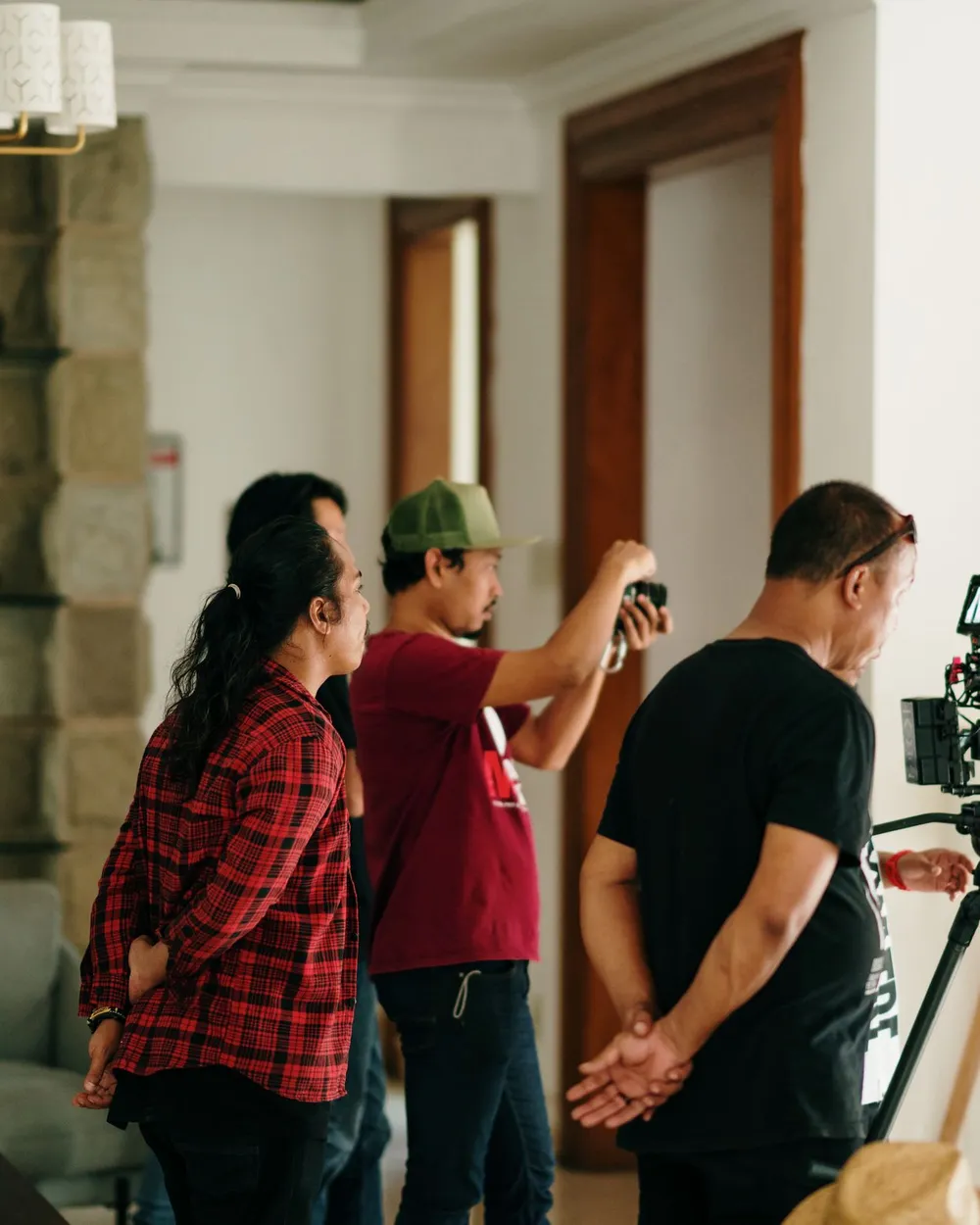 Equipe criativa reunida em mesa de trabalho com telas e material impresso