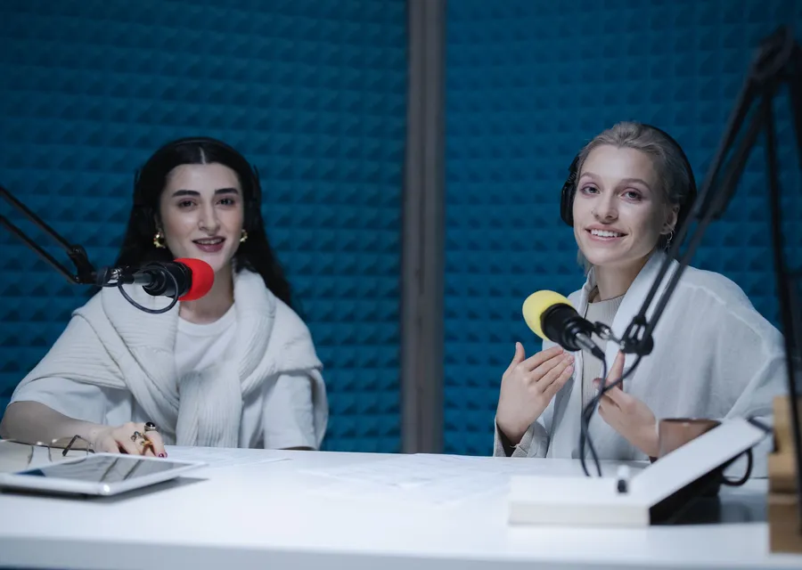 Duas pessoas em estúdio, entrevista com microfones
